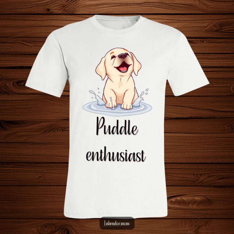 Funny T-shirt depicting a labrador dog joyfully splashing and playing in a muddy puddle, full of messy fun.